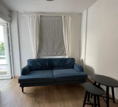 a blue couch in a living room with a window at Lovely 1-bd apt with patio in Nicosia center in Nicosia