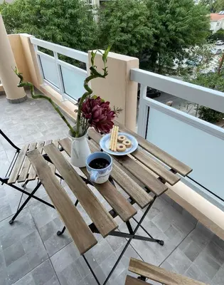 a wooden table with a plate of food on a balcony at Lovely 1-bd apt with patio in Nicosia center in Nicosia