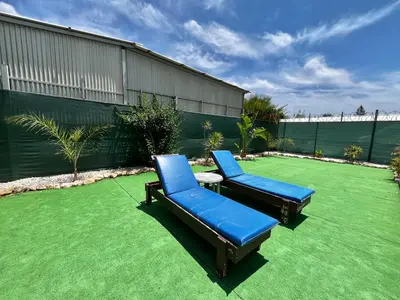 two blue chairs sitting on a green lawn at STAY Pernera House in Ayia Napa