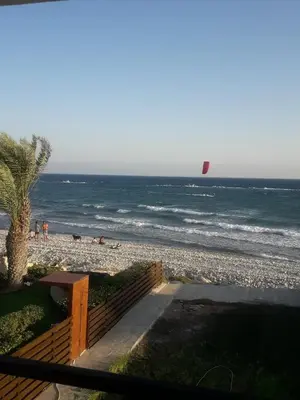 a person flying a kite on the beach at SEAFRONT BEACH PARTY VILLA in Pervolia