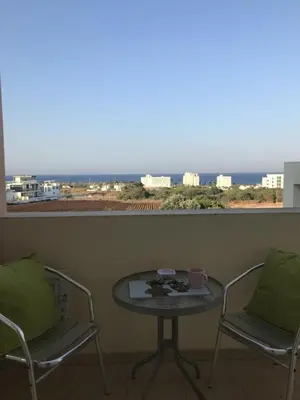 a table and chairs in a balcony with a view of the ocean at Protaras, Janas apartment in Protaras