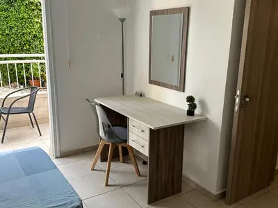 a desk with a mirror and a chair in a room at Olymbos Garden Apartment IV in Ayia Napa
