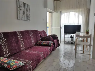 a living room with a purple couch and a television at 1 bedroom apartment with a magnificent sea view in Limassol