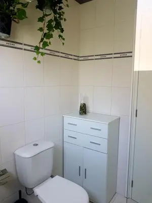 a white bathroom with a toilet and a sink at Panorama Village Complex in Paralimni