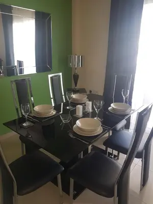 a black dining room table with chairs and plates at Panorama Village Complex in Paralimni