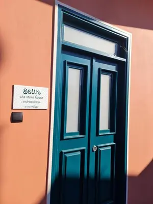 a blue door with a sign on the side of a building at Selin the stone house in Limassol