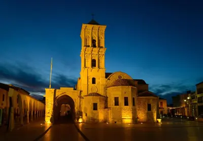 a large building with a clock tower at night at Hidden Gem City Studio in Larnaka