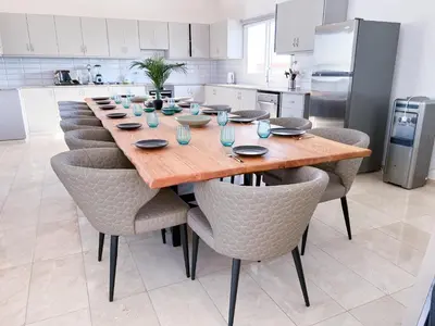 a kitchen with a long wooden table and chairs at Grand villa Lynn seaview Ayia Napa in Ayia Napa