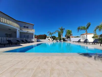 a swimming pool in a villa with palm trees at Grand villa Lynn seaview Ayia Napa in Ayia Napa