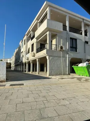a building with a green bench in front of it at Mad beach in Protaras