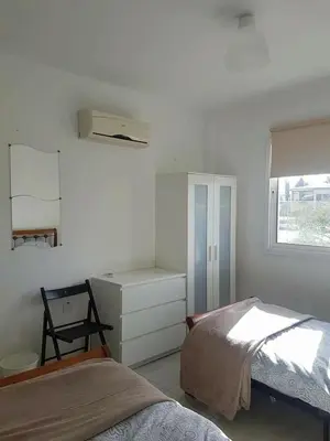 a bedroom with a bed and a dresser and a window at Armstrong Apartment in Paralimni