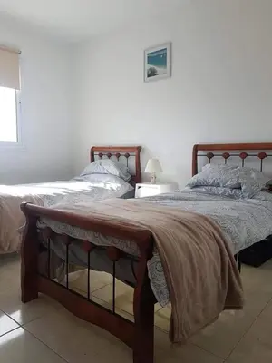 a bedroom with two beds with a blanket on them at Armstrong Apartment in Paralimni