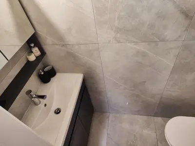 a bathroom with a tub and a toilet and a sink at Pampering Beach Dream, A Stunning Luxury Retreat at Yialos Village in Meneou