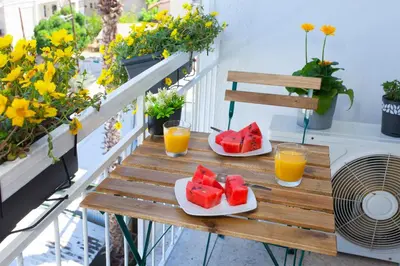 two plates of watermelon and orange juice on a table on a balcony at ARTEMIS 3, Beachfront Boutique Apartment in Limassol