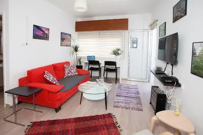 a living room with a red couch and a table at ARTEMIS 3, Beachfront Boutique Apartment in Limassol