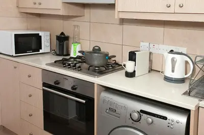 a kitchen with a stove top oven next to a microwave at ARTEMIS 3, Beachfront Boutique Apartment in Limassol