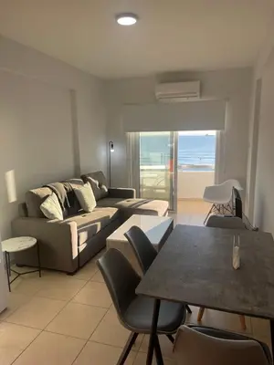 a living room with a couch and a table with chairs at Alex Beach Apartment 34 in Larnaka