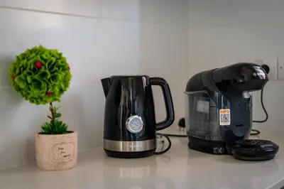 a kitchen counter with a coffee maker and a coffee pot at Majestic Sunset Salt Lake Views 300m from beach in Larnaka