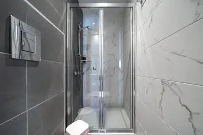 a shower with a glass door in a bathroom at Majestic Sunset Salt Lake Views 300m from beach in Larnaka