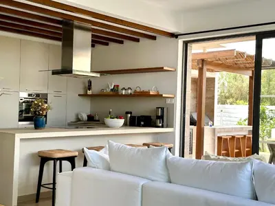 a living room with a white couch and a kitchen at Lora Pearl Luxury Villa in Protaras