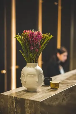 a vase with flowers in it sitting on a table at The Icon Limassol in Limassol