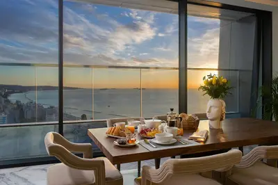 a dining room with a table and a view of the ocean at The Icon Limassol in Limassol