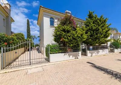 a fence in front of a house with trees at Villa Alexander in Protaras