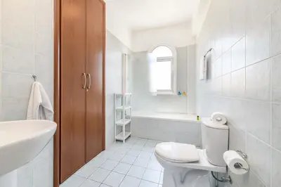 a white bathroom with a toilet and a sink at Villa Alexander in Protaras
