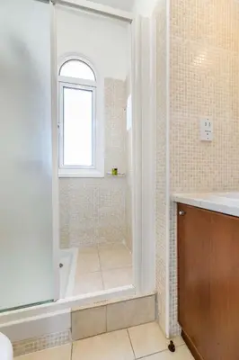 a bathroom with a tub and a shower with a window at Villa Alexander in Protaras