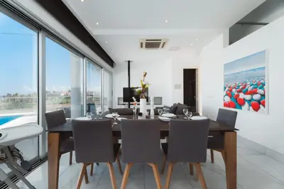 a dining room with a table and chairs at Seaside Luxury Villa with Heated Pool in Paralimni