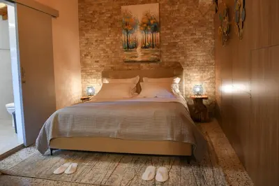 a bedroom with a bed and a brick wall at Sophias Cottage in Askas