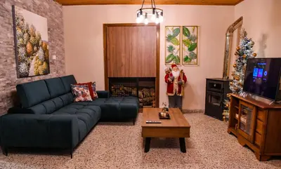a living room with a couch and a christmas tree at Sophias Cottage in Askas