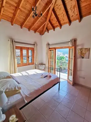 a bedroom with a bed and a large window at Unique Stonehouse Traditional Villa in Ayia Anna in Ayia Anna