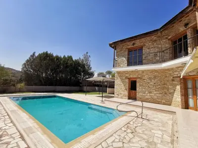 a swimming pool in front of a house at Unique Stonehouse Traditional Villa in Ayia Anna in Ayia Anna