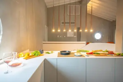 a kitchen with a counter with vegetables and glasses of wine at Protaras Art House Seviews in Protaras