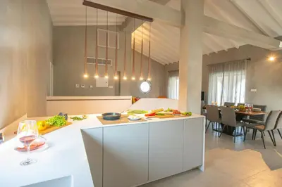 a kitchen with white cabinets and a dining room at Protaras Art House Seviews in Protaras