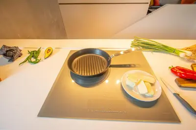 a pot on a cutting board with a plate of food at Protaras Art House Seviews in Protaras