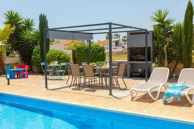 a patio with a table and chairs next to a pool at Ayia Napa Marina Vibes in Ayia Napa