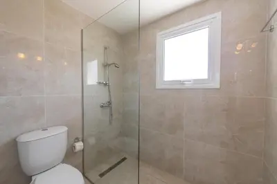 a bathroom with a toilet and a glass shower at Ayia Napa Marina Vibes in Ayia Napa