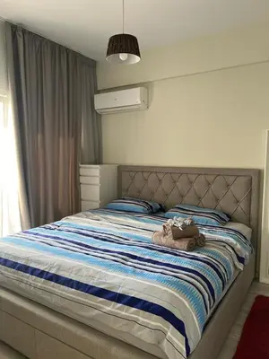 a large bed with a blue and white striped blanket at Cozy Apartment by the sea in Limassol