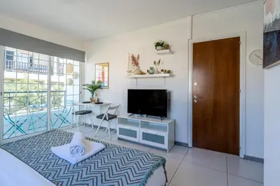 a living room with a television and a door at Sofia's Cosy Studio in Larnaca in Larnaka