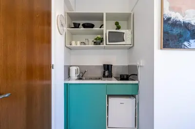 a small kitchen with a sink and a microwave at Sofia's Cosy Studio in Larnaca in Larnaka