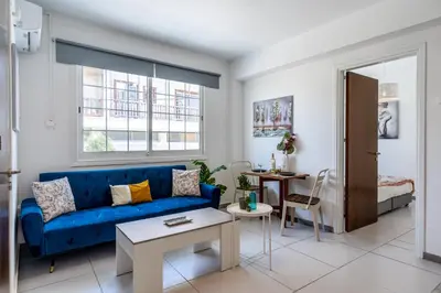 a living room with a blue couch and a table at Mila's 1-BR Apartment in Larnaca in Larnaka