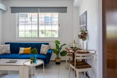 a living room with a blue couch and a table at Mila's 1-BR Apartment in Larnaca in Larnaka