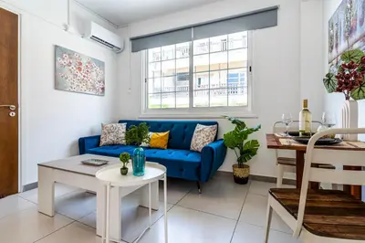 a living room with a blue couch and a table at Mila's 1-BR Apartment in Larnaca in Larnaka
