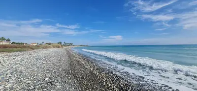 a beach with a rocky shoreline and the ocean at Villa del Mar Heated pool in Mazotos