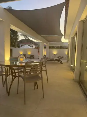 a patio with a table and chairs on a building at Katikies Grand in Pissouri