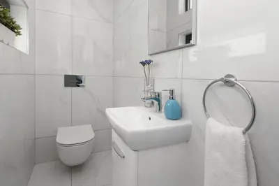 a white bathroom with a sink and a toilet at Villa Theresa in Protaras