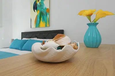 a bowl of shells on a table with a vase at Villa Theresa in Protaras