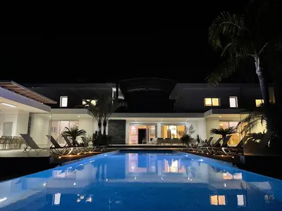 a swimming pool in front of a house at night at Bay View Villa in Protaras